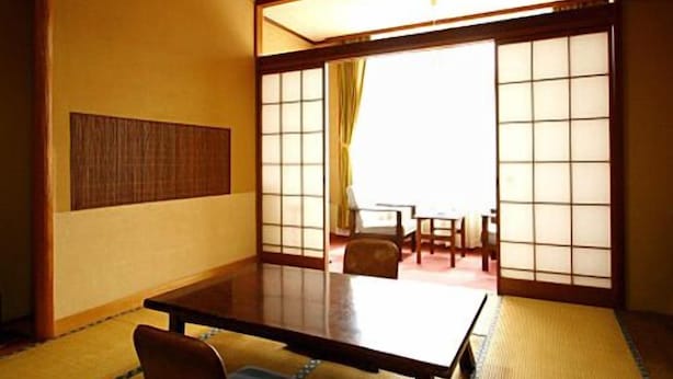 A traditional Japanese room with tatami flooring, a low table, and sliding shoji doors. - Nakahamaya (Izu)