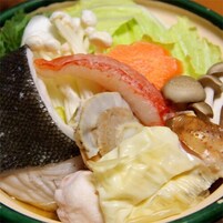 Un tazón con mariscos variados, incluyendo pescado, camarones y champiñones.