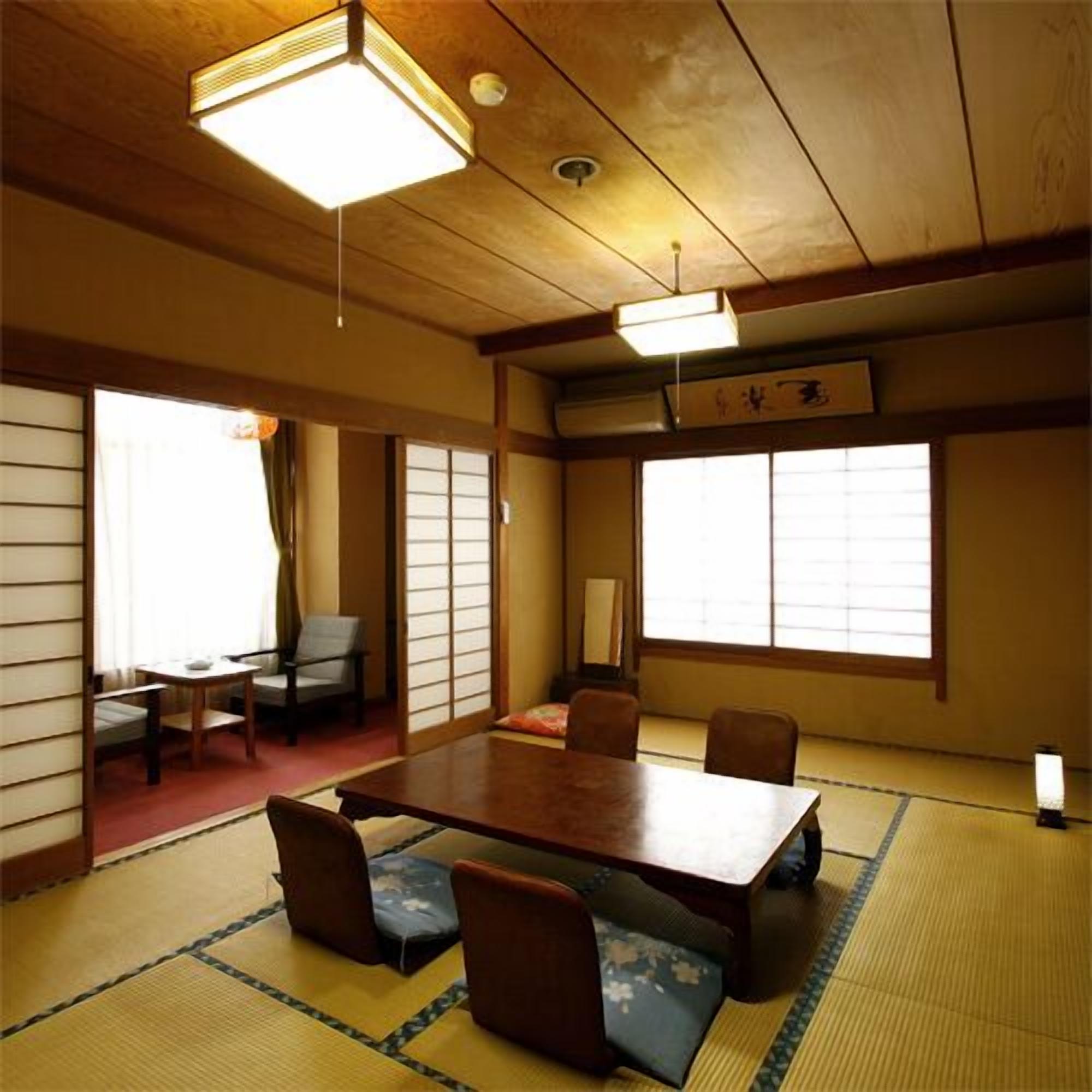 A traditional Japanese room with tatami flooring, a low table, and sliding doors.