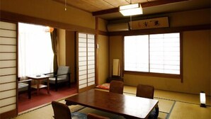 A traditional Japanese room with tatami flooring, a low table, and sliding doors. - Nakahamaya (Izu)