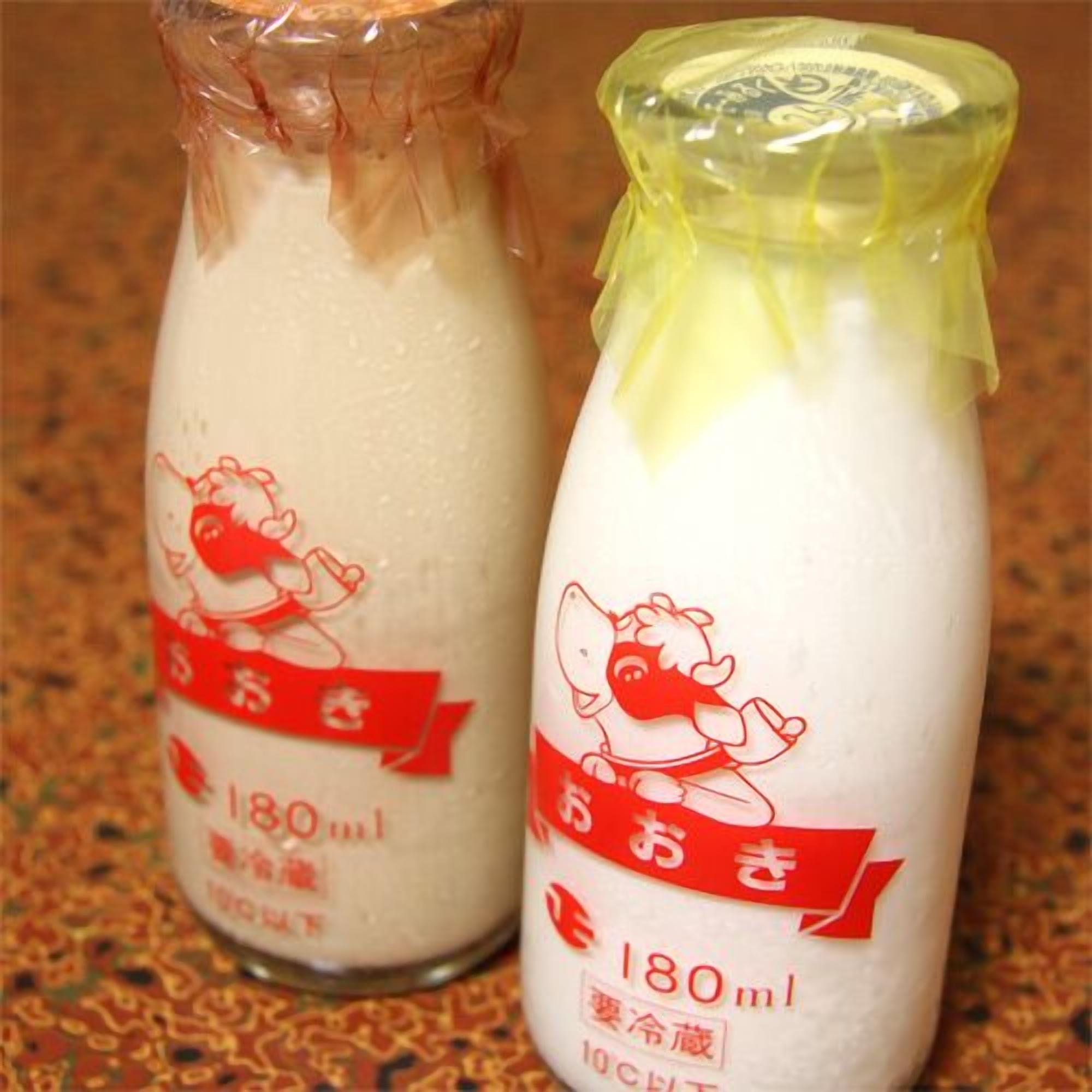 Two bottles of milk with a cartoon cow on the label, each containing 180ml.