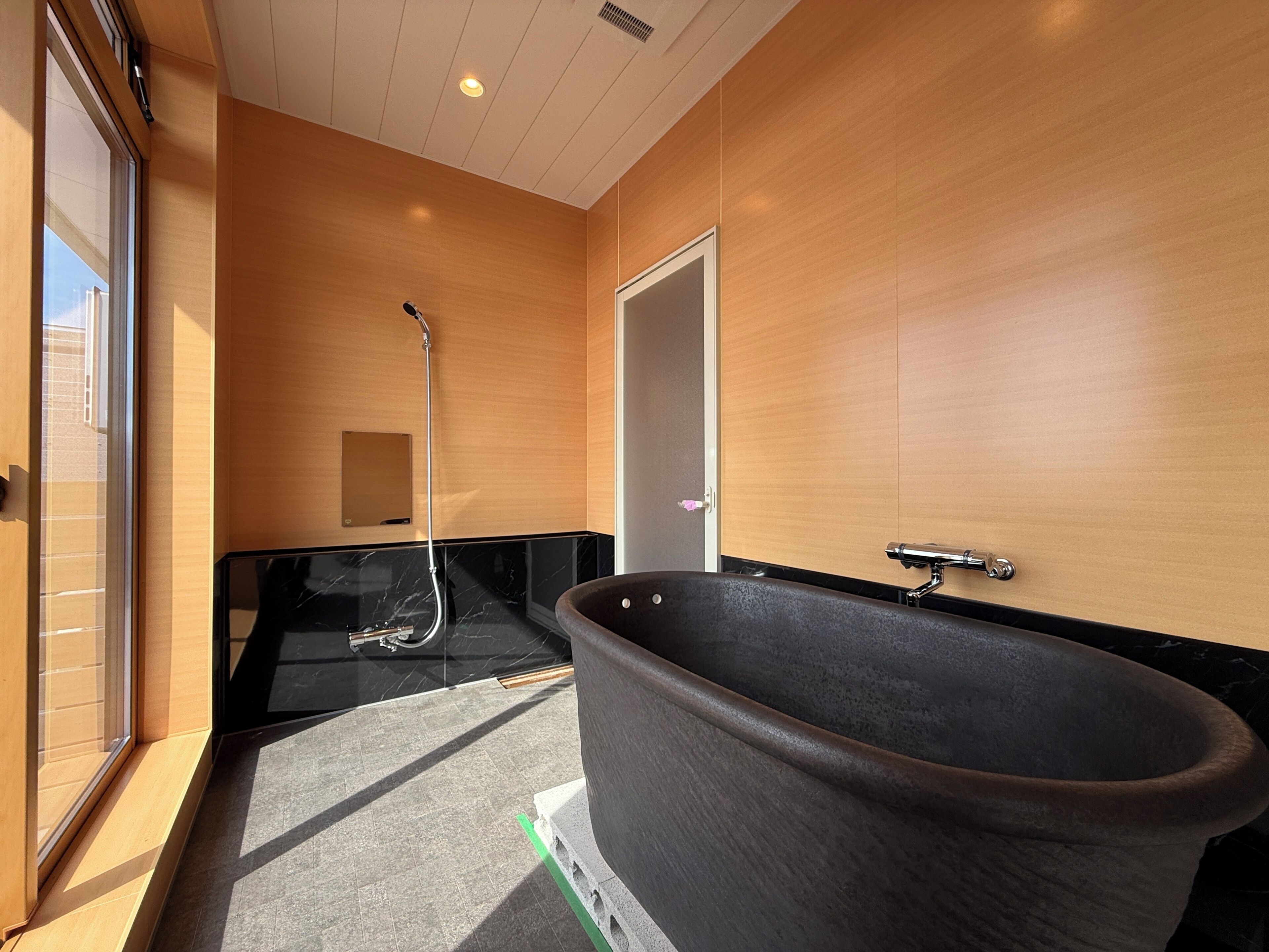 Une salle de bain moderne dotée d’une grande baignoire, d’une douche et d’un meuble-lavabo avec un miroir.