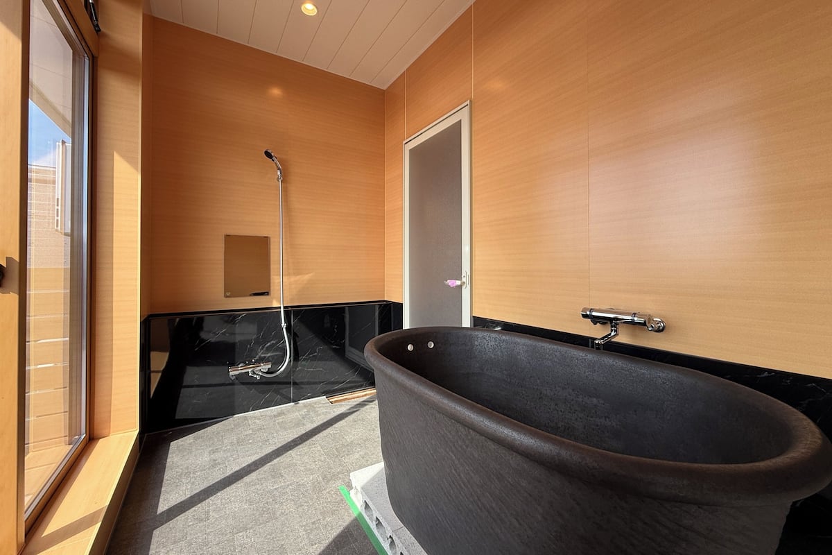 Un baño moderno con una bañera grande, ducha y tocador con espejo.