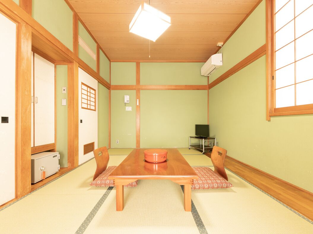 Een traditionele Japanse kamer met tatami vloerbedekking, een houten tafel en verschuifde deuren.