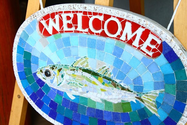 Une enseigne d’accueil en mosaïque ornée d’un motif de poisson.