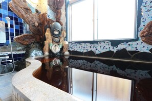 A bathroom with a curved sink, a mirror, and a mosaic wall. - Oonoso (Onjuku)