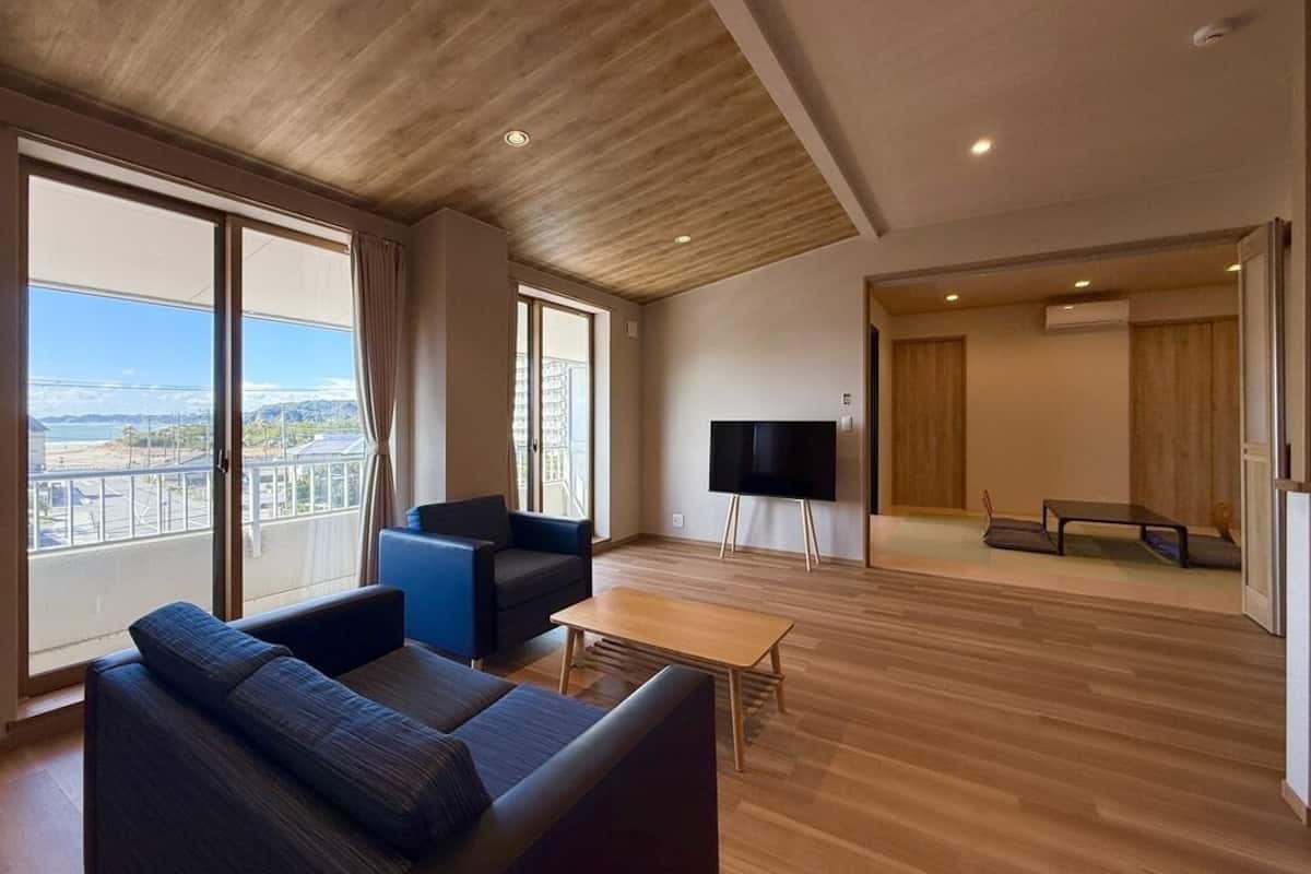 Un salon moderne avec un canapé, une table basse et un téléviseur à écran plat.