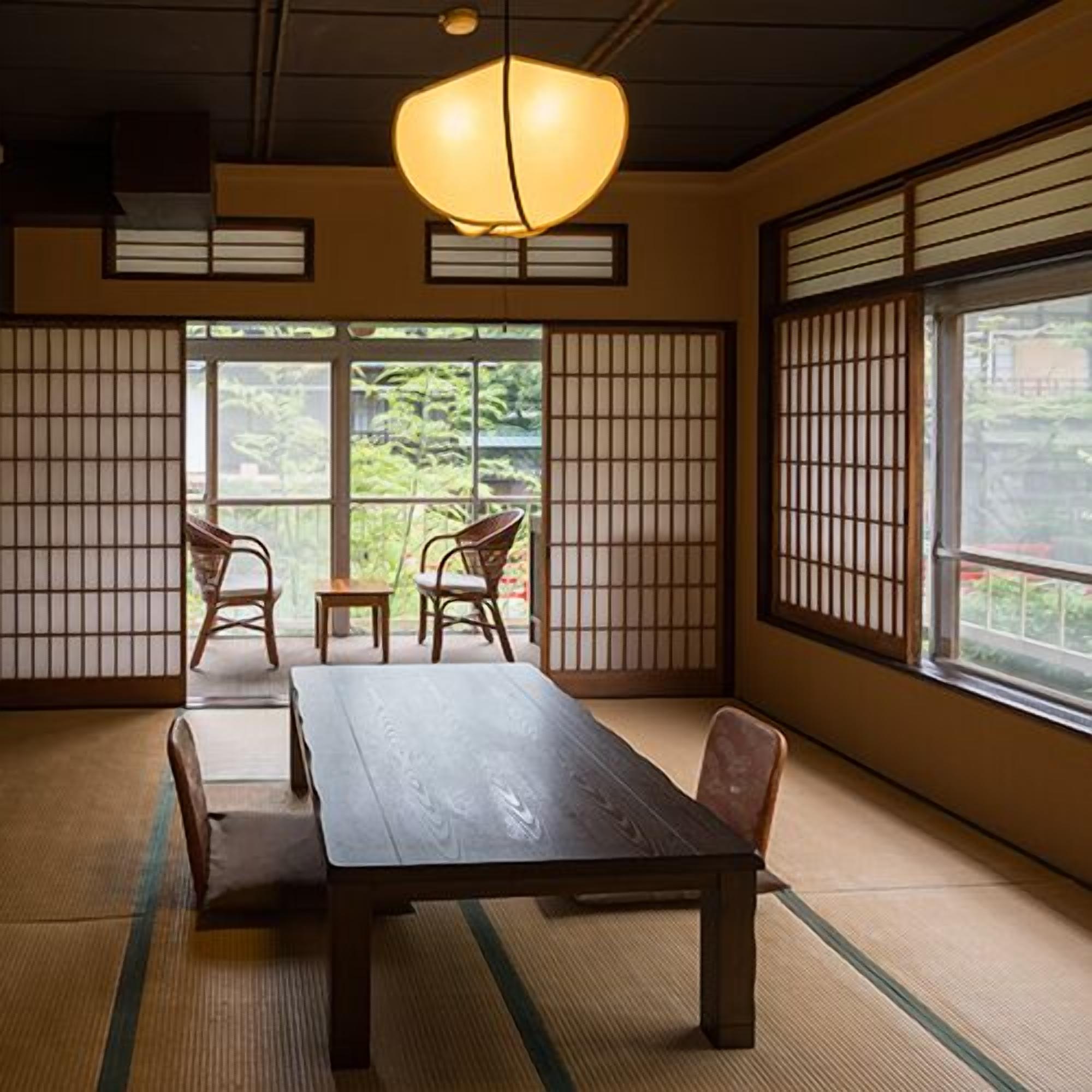 A traditional Japanese room with tatami flooring, a low table, and sliding doors.