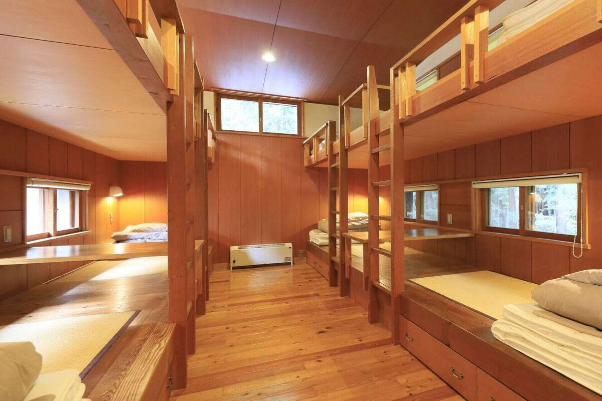 Una cabaña con literas, pisos de madera y ventanas amplias.