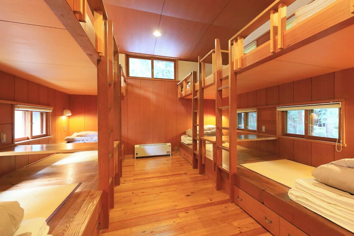 Una cabaña con literas, pisos de madera y ventanas.