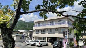 A multi-story building with a flat facade, several windows, and a visible entrance. - Kamisuwa Onsen Minshuku Ahiru (Suwa)