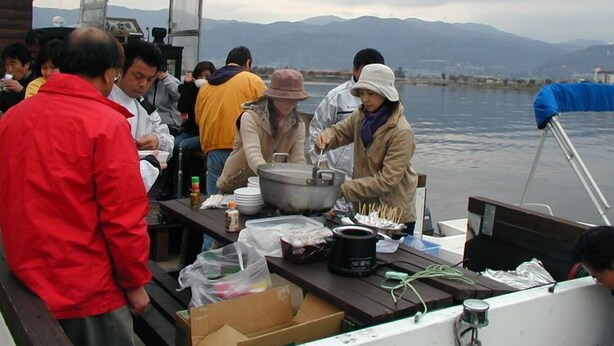 A group of people on a boat with a cooking setup on deck. - Kamisuwa Onsen Minshuku Ahiru (Suwa)