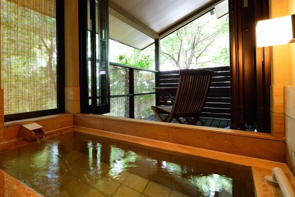 A hot spring bath with wooden walls and large windows.