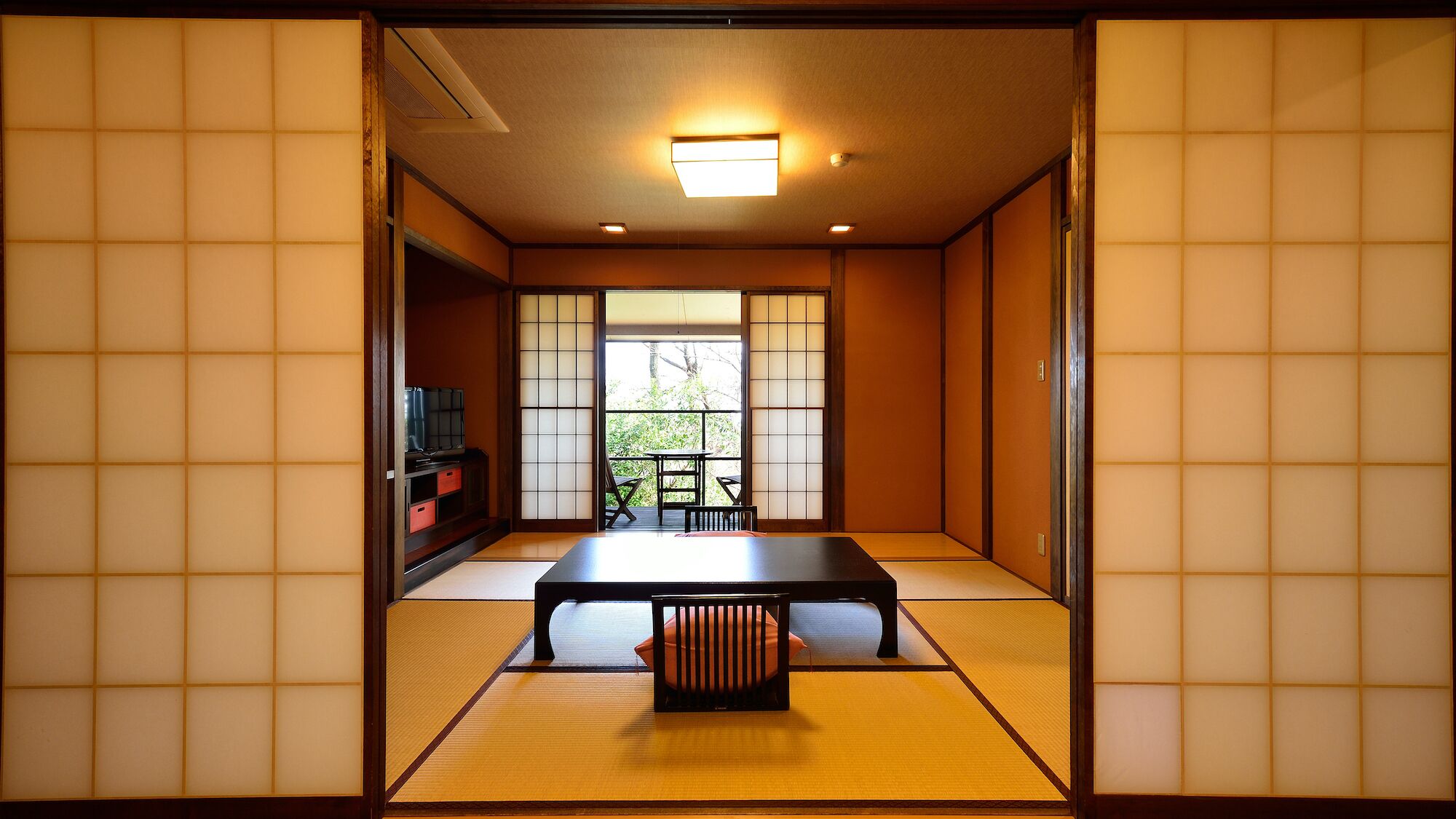 Ett traditionellt japanskt rum med tatamimattor på golvet, ett lågt bord och skjutdörrar.