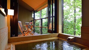 A wooden deck with a hot tub, wooden chairs, and a table with glasses and bottles. - Hanareyado Yumenoya (Ito)