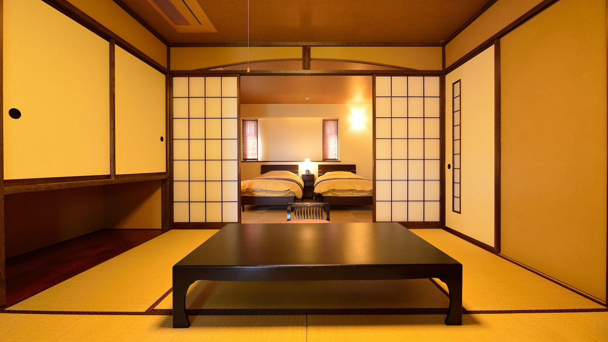 A traditional Japanese-style room with tatami flooring, a low table, and sliding doors.