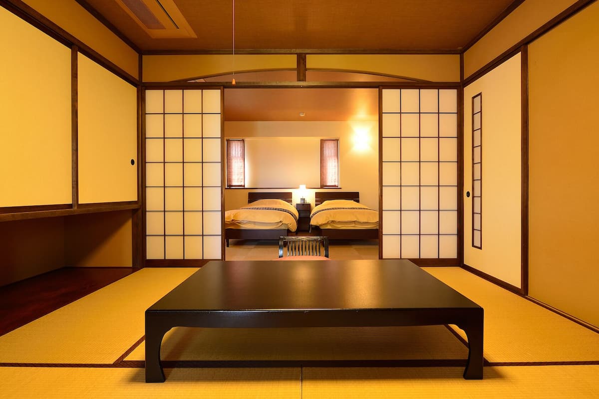A traditional Japanese-style room with tatami flooring, a low table, and sliding doors.
