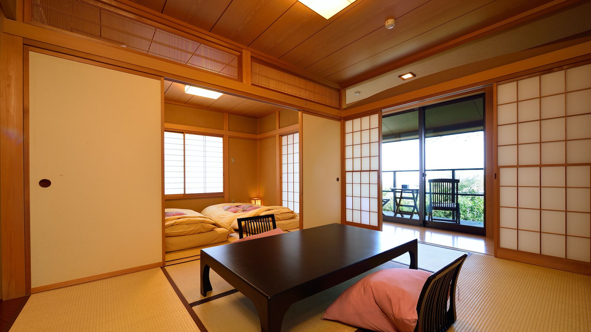 A traditional Japanese room with tatami flooring, a low table, and sliding doors.