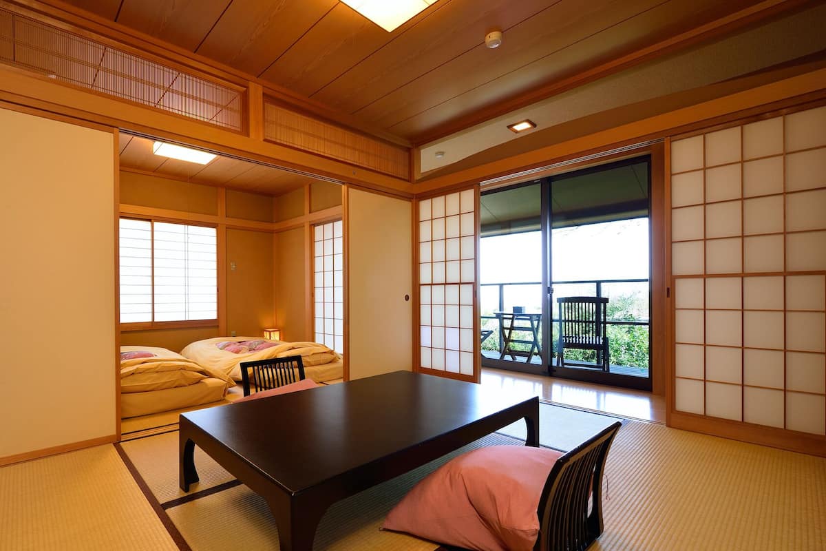 A traditional Japanese room with tatami flooring, a low table, and sliding doors.