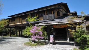 A traditional Japanese building with a wooden structure, a covered entrance, and signage indicating a business. - Kurokawa Onsen Iyashi no Sato Kiyashiki (Minamioguni)