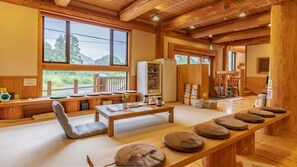 Un intérieur en bois avec une longue table, des bancs et un réfrigérateur.