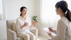 Une pièce avec un canapé, une plante en pot et une personne tenant un classeur.
