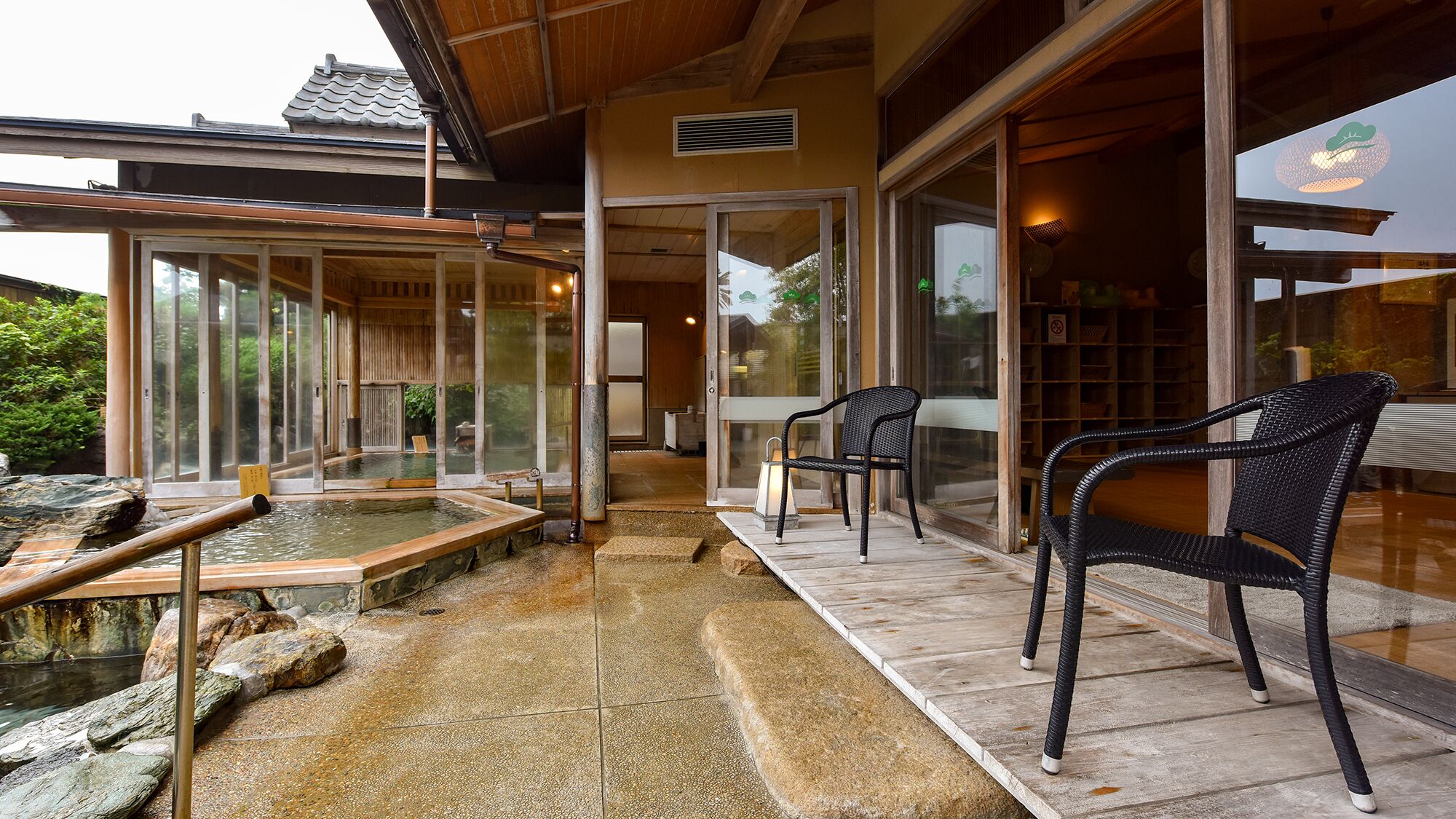 Un onsen japonais traditionnel, avec des bancs en pierre et une structure en bois.