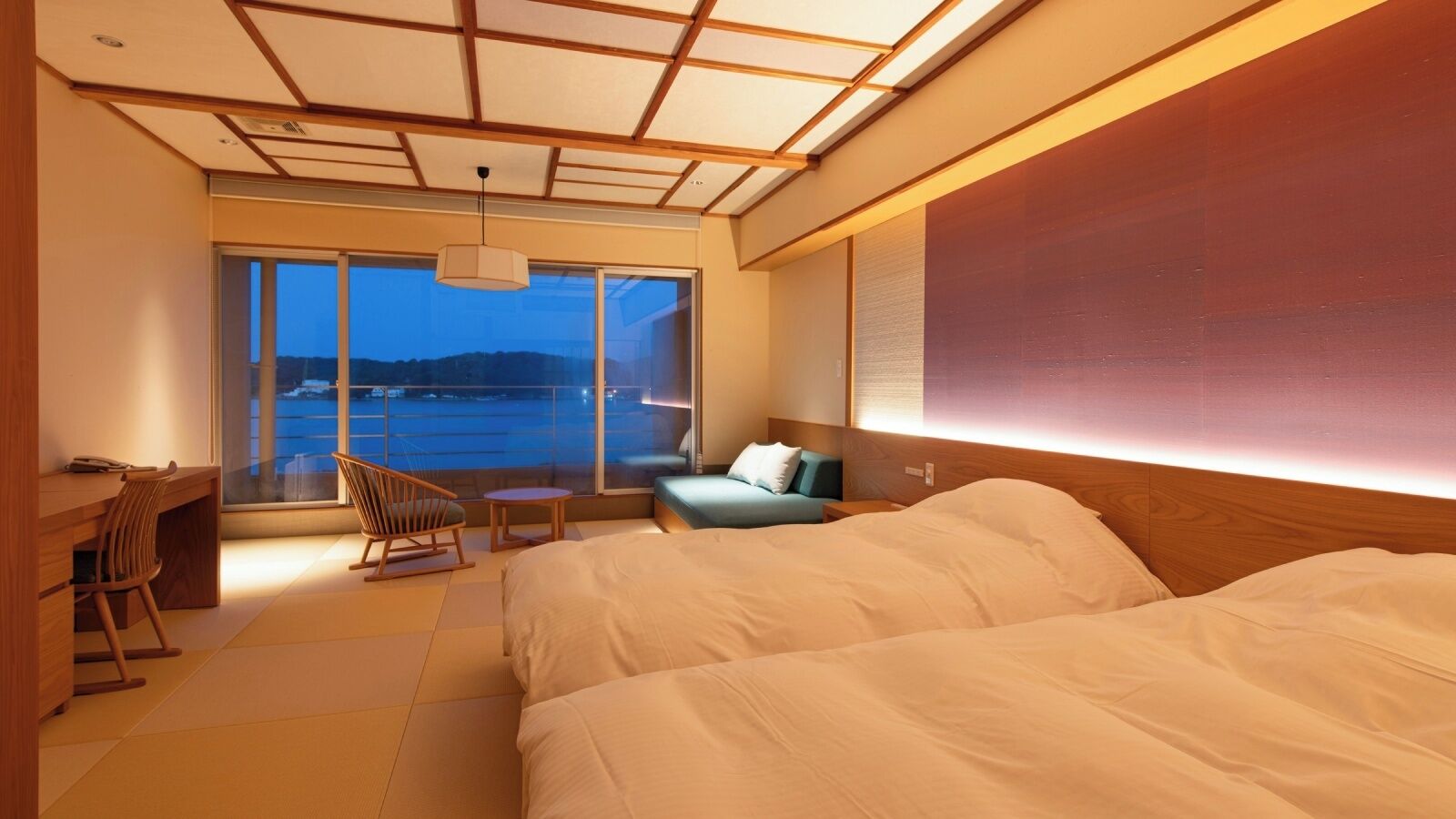 Une chambre d’hôtel avec un grand lit, un bureau, une chaise, une petite table et un canapé.
