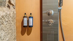 Casa de banho com chuveiro e duas embalagens de shampoo e gelo da Damana.