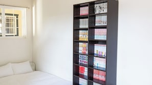 Una camera da letto con un letto, una finestra e una libreria piena di libri.