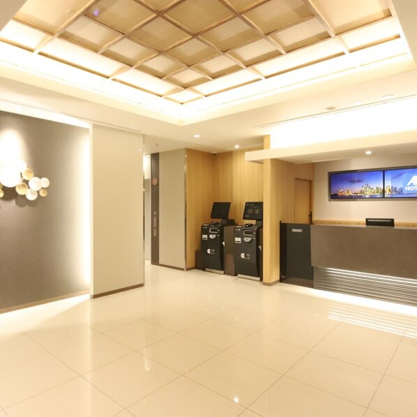 A hotel reception area with a modern design, including a reception desk, a digital screen, and a self-service kiosk. - AB Hotel Iga Ueno (Iga)