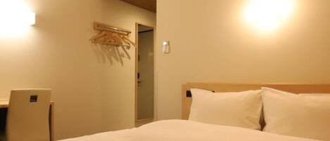 Ein Hotelzimmer mit einem Bett, einem Schreibtisch und einer Klimaanlage.