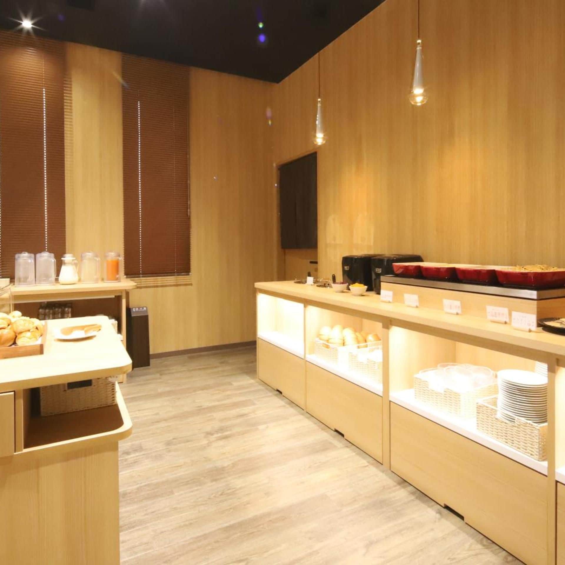 A modern kitchen with wooden walls and a counter displaying various food items.