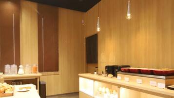 A modern kitchen with wooden walls and a counter displaying various food items.