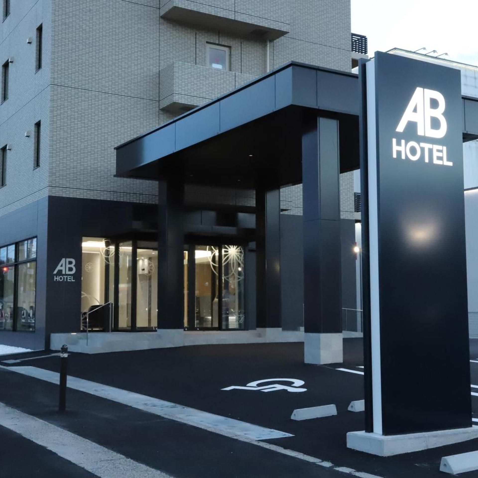 A hotel entrance with a modern design, including a covered entrance area and a prominent sign.