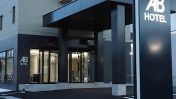 A hotel entrance with a modern design, including a covered entrance area and a prominent sign.