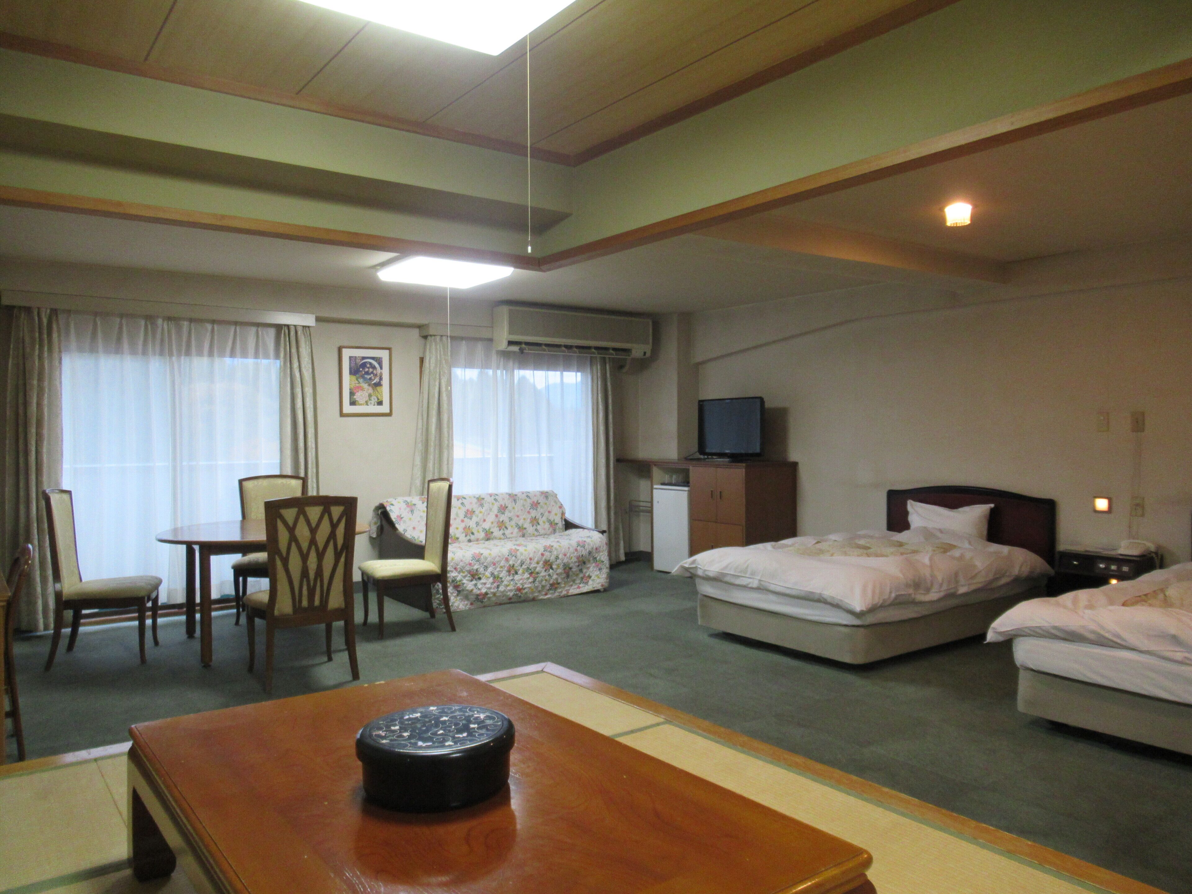 Une chambre d’hôtel équipée d’un lit, d’un bureau, d’une chaise, d’une télévision et d’un appareil de climatisation.