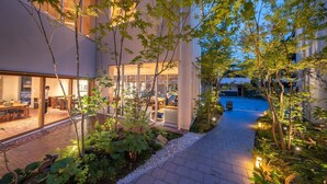 A courtyard with a dining area, a pathway, and a pool.