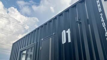A black shipping container with the number '01' and 'FMB 24014' on it.