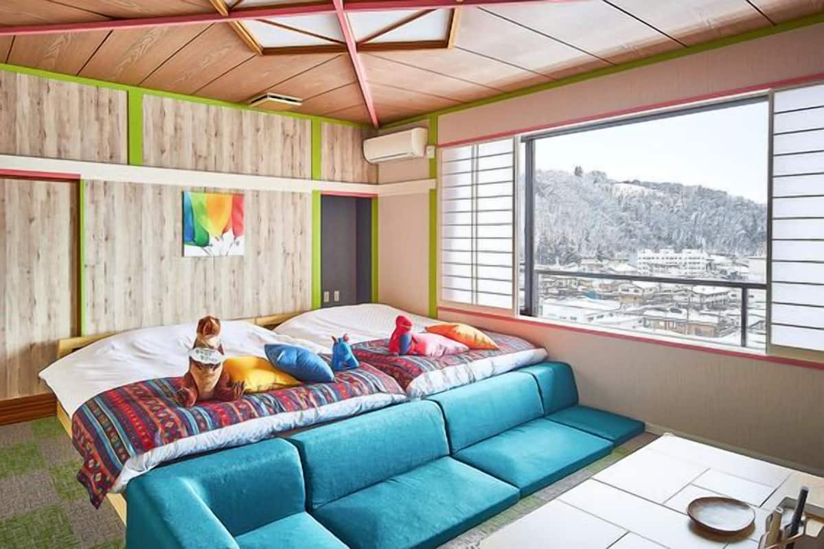 Ein Schlafzimmer mit Bett, einer Couch, einem Fenster mit Blick und einem Schreibtisch.