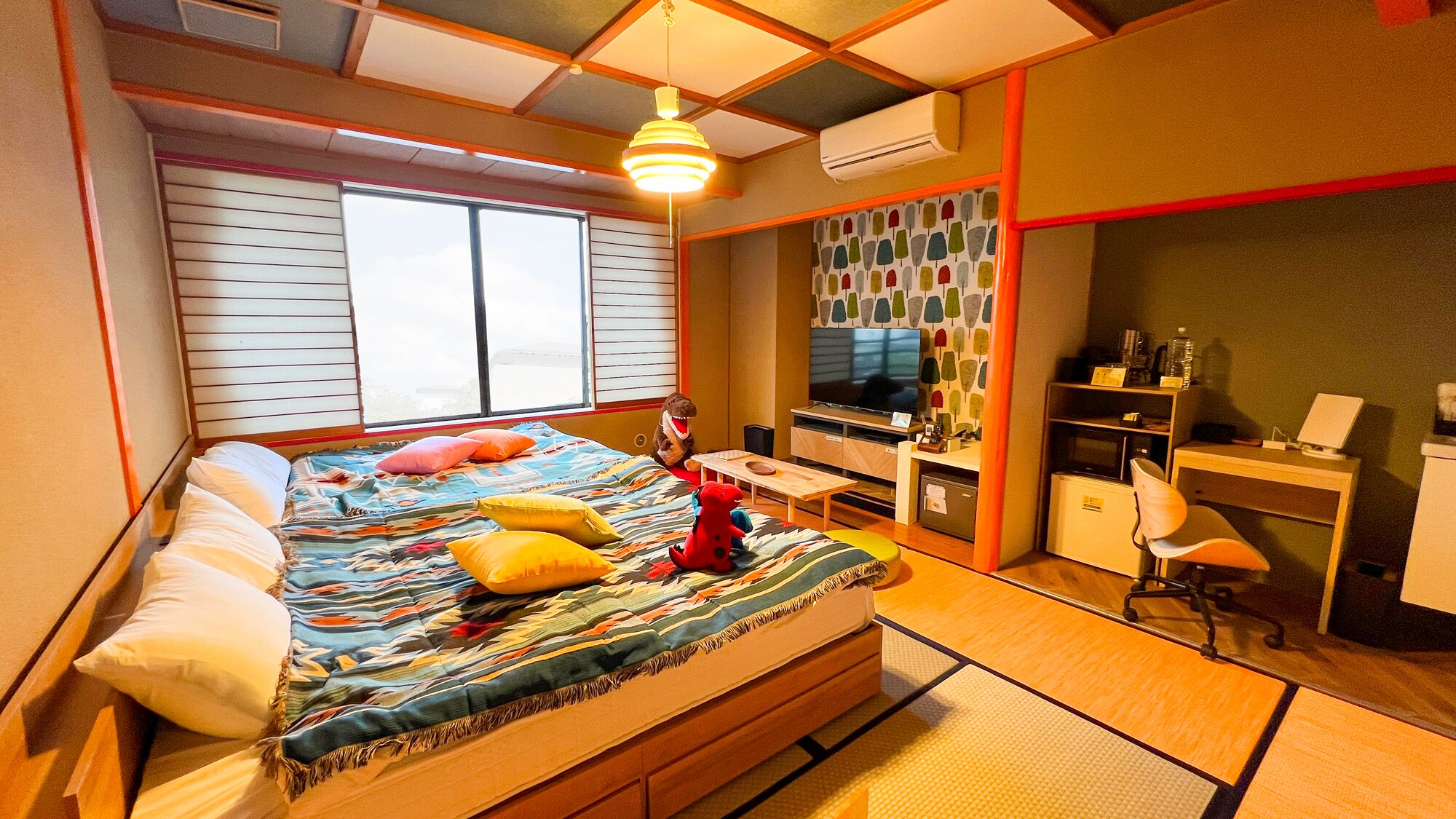 Ein Schlafzimmer mit Bett, Schreibtisch, Stuhl, Fernseher und Klimaanlage.