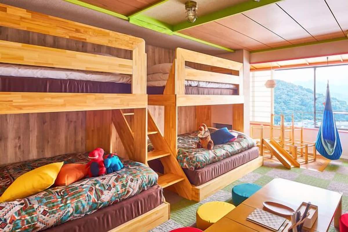 Ein Zimmer mit Etagenbetten, einer Schlafcouch, einer Hängematte und Blick ins Freie.
