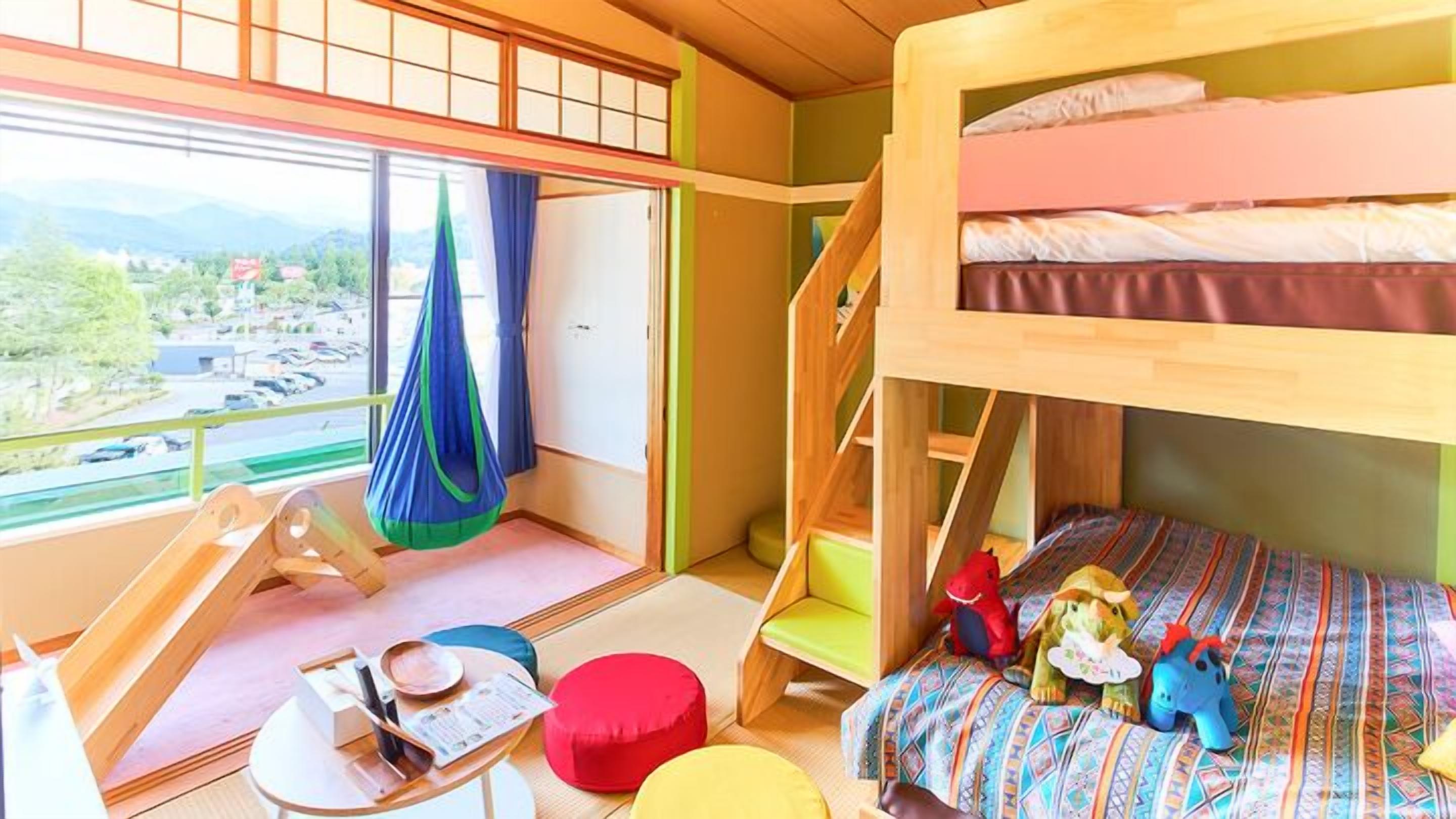 Ein Mehrbettzimmer mit Blick auf einen Parkplatz und Berge.