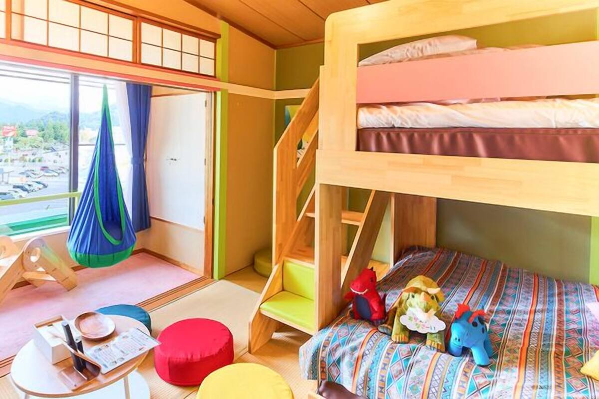 A bunk bed room with a view of a parking lot and mountains.