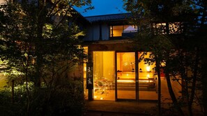 A modern building with large glass doors, a visible interior with a dining area, and a tree-lined entrance. - Shibayama Onsen Maruya (Kami)