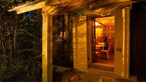 A wooden cabin with an open door, a bench outside, and a sign indicating the room is open. - Shibayama Onsen Maruya (Kami)