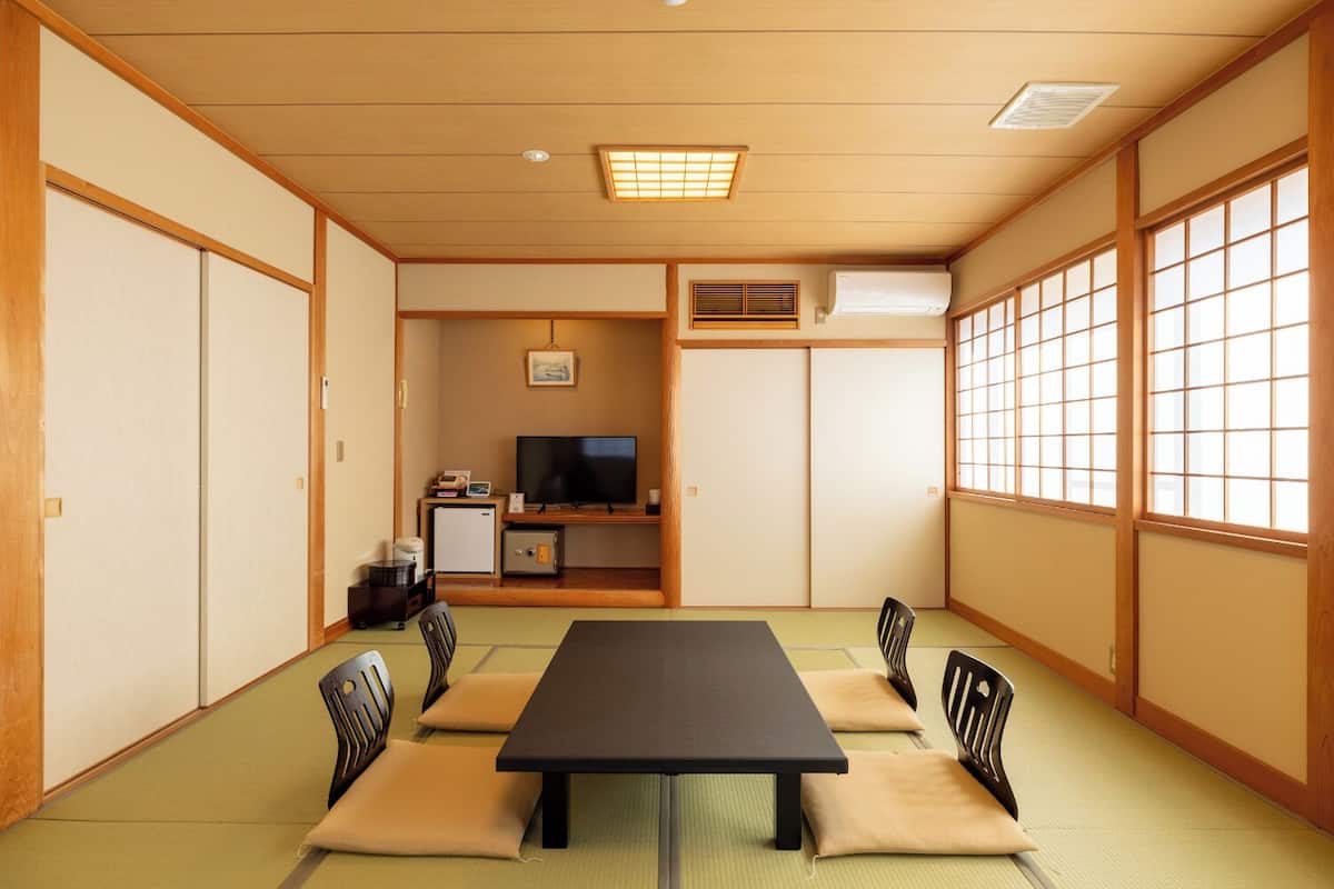 A traditional Japanese-style room with tatami flooring, a low table, and shoji screens.