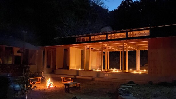 Un edificio moderno con amplias ventanas y una chimenea en primer plano.
