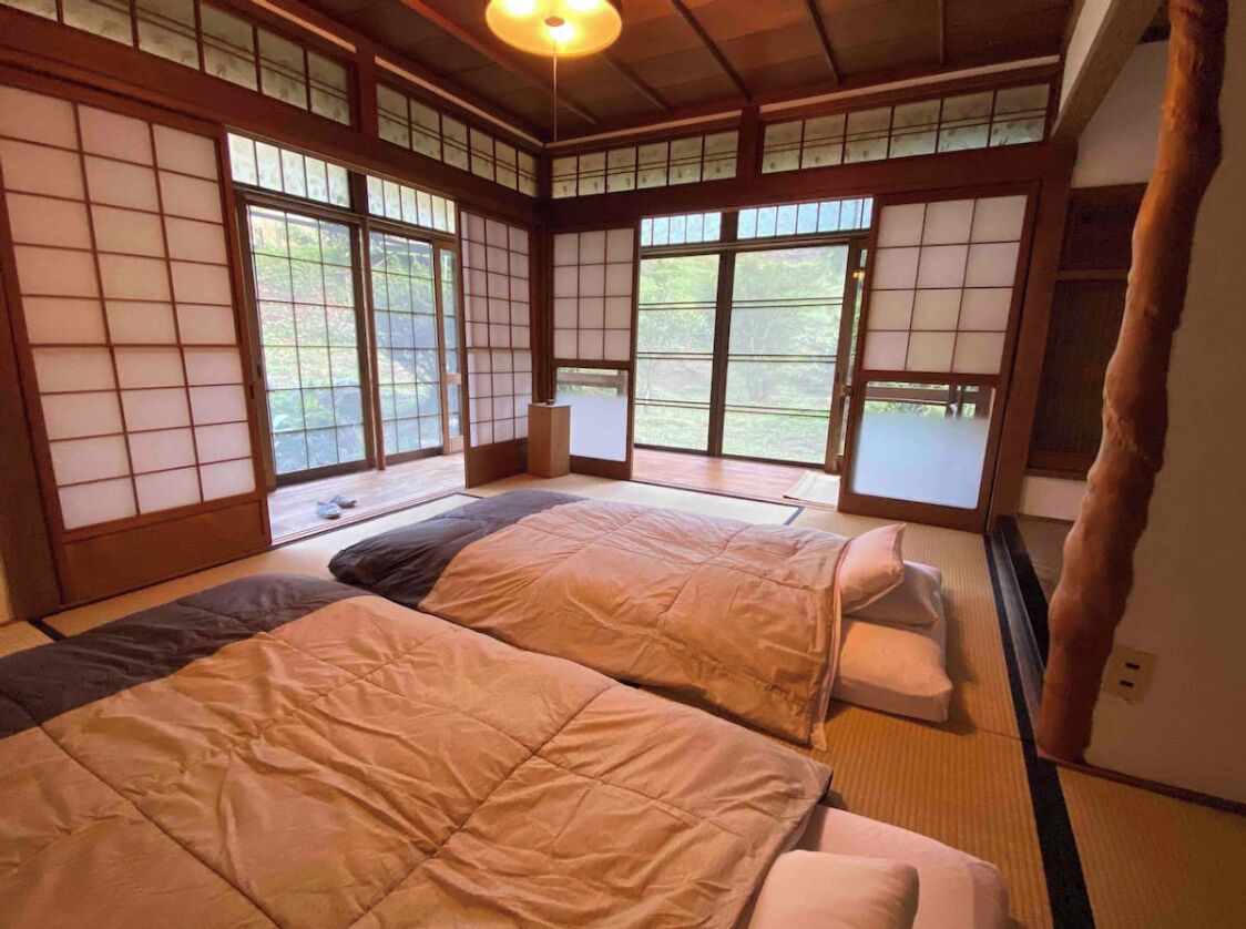 A traditional Japanese-style room with tatami flooring, sliding doors, and a low ceiling.