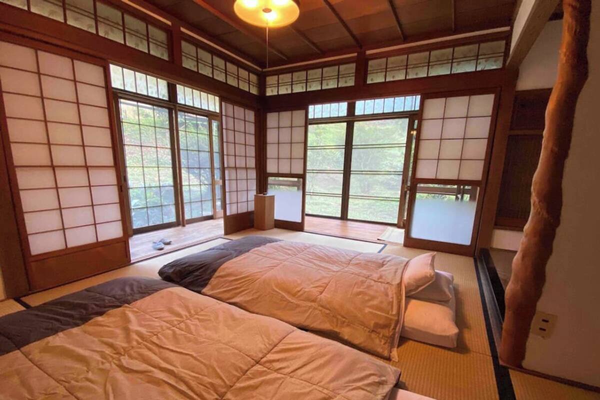 Una habitación tradicional japonesa con suelo de tatami, puertas correderas y techo bajo.